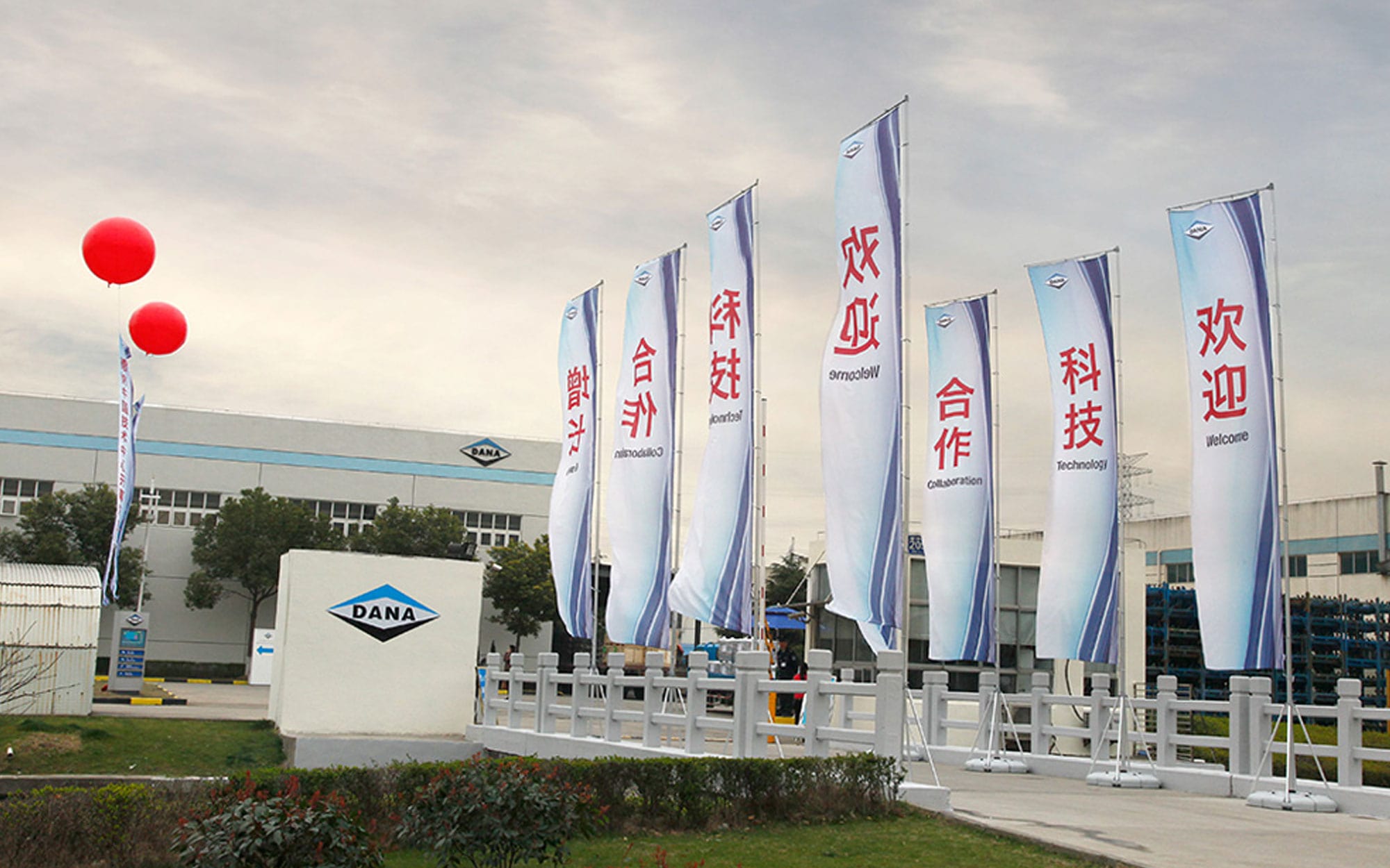 Dana Incorporated manufacturing facility in China featuring branded event flags and signage during a global public relations launch event managed by Gelia.